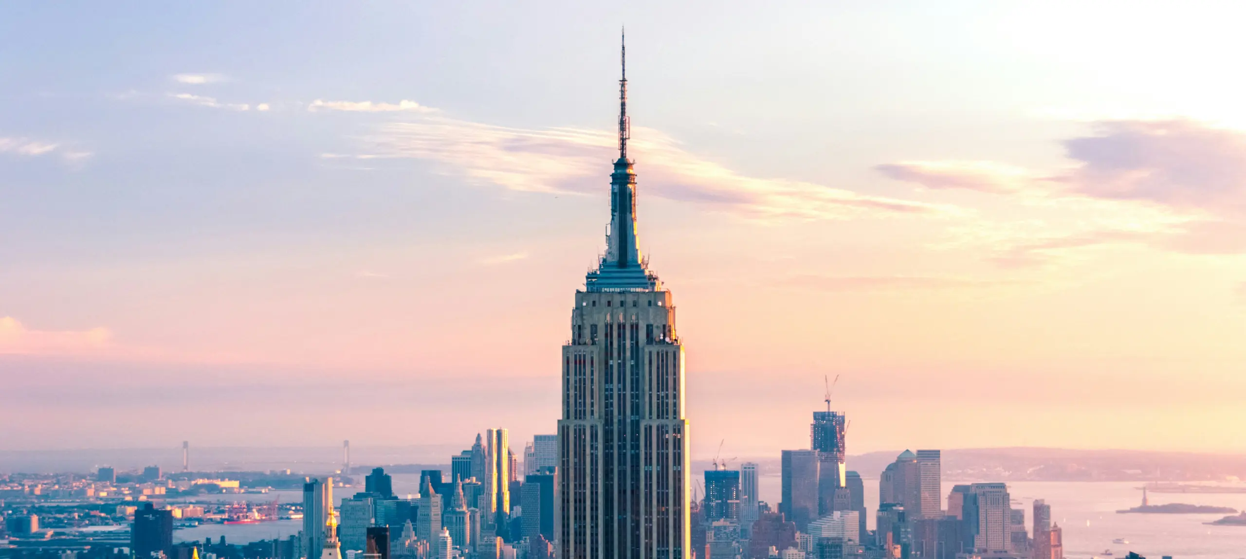 Midtown Manhattan at golden hour, the Empire State Building against a pale sky